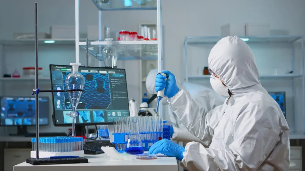About Us 7 man scientist coverall using micropipette modern equipped laboratory team doctors examining vaccine evolution with high tech chemistry tools research development covid19 virus 1